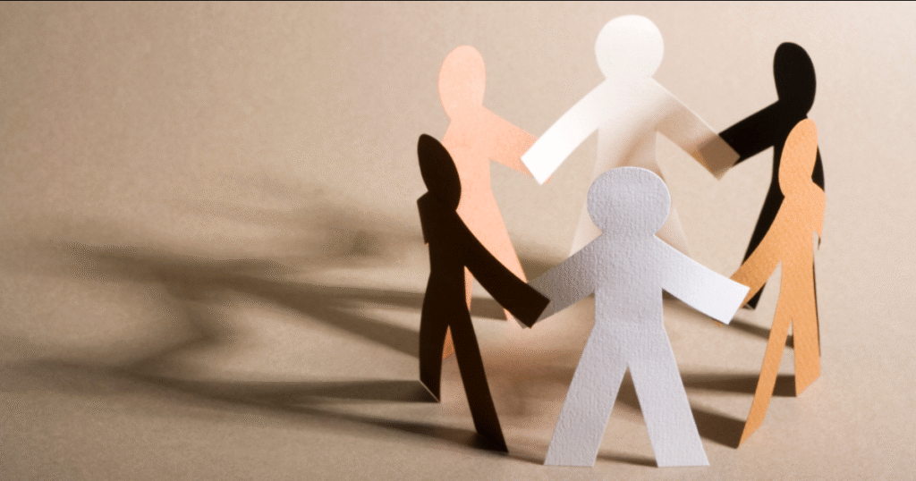 Diverse paper figures holding hands symbolizing unity.