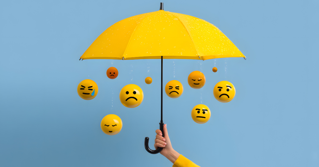 Yellow umbrella with hanging emoticons.