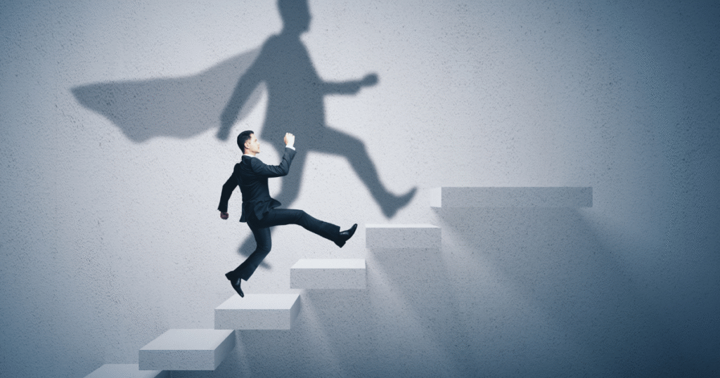 Businessman climbing stairs with superhero shadow.