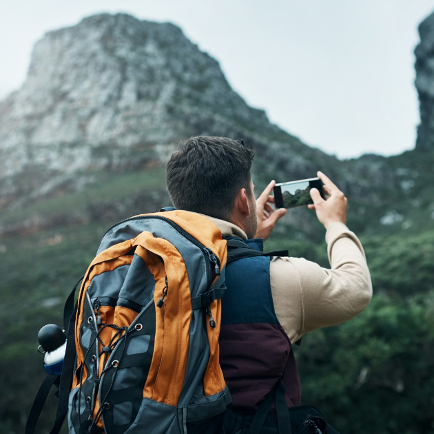 Wellismo Blog Social Share (10) Person hiking and photographing mountains with smartphone.